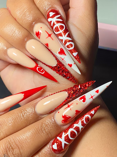 A woman's hand with red and white nail art