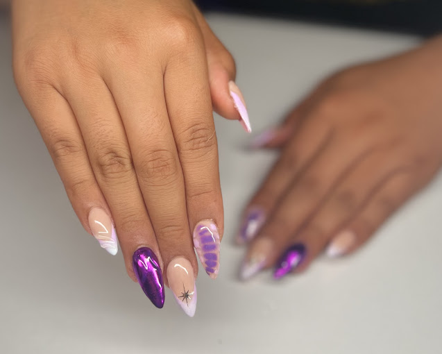 A woman's hand with a purple and white manicure